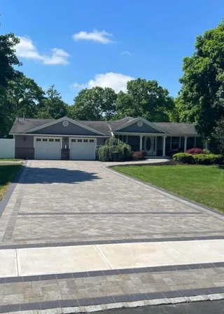 Finished paver driveway and decorative apron in front of a single-story home.