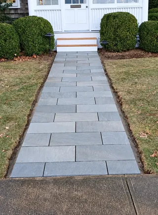 Rectangular stone front walkway leading toward a home.