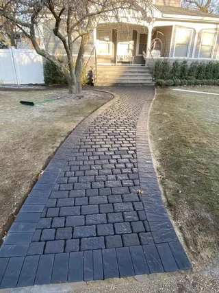 Finished curved heated paver walkway leading from the front yard to the porch.